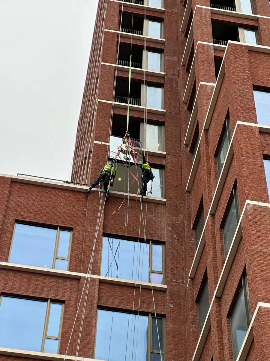 Glass installation with a vacuum lifter at a façade opening.