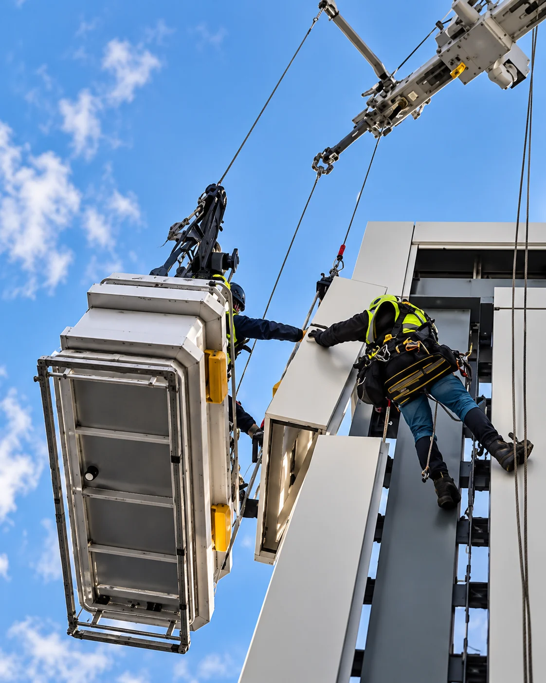 Façade panel installation at height. AI-enhanced illustration based on a project video still.