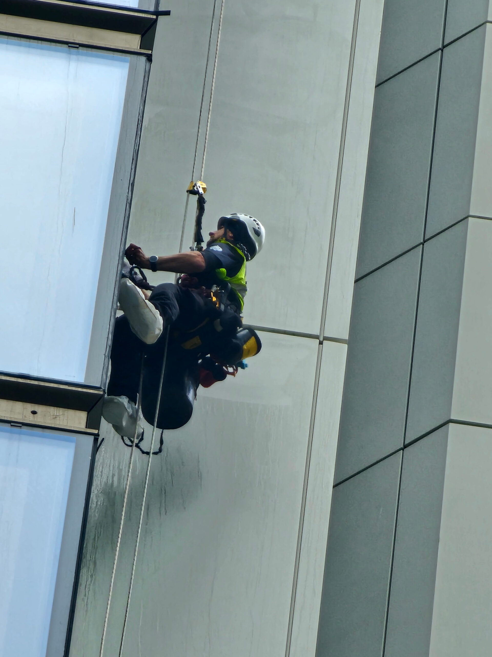 Multi-technician rope access operation supporting façade maintenance on a high-rise elevation.