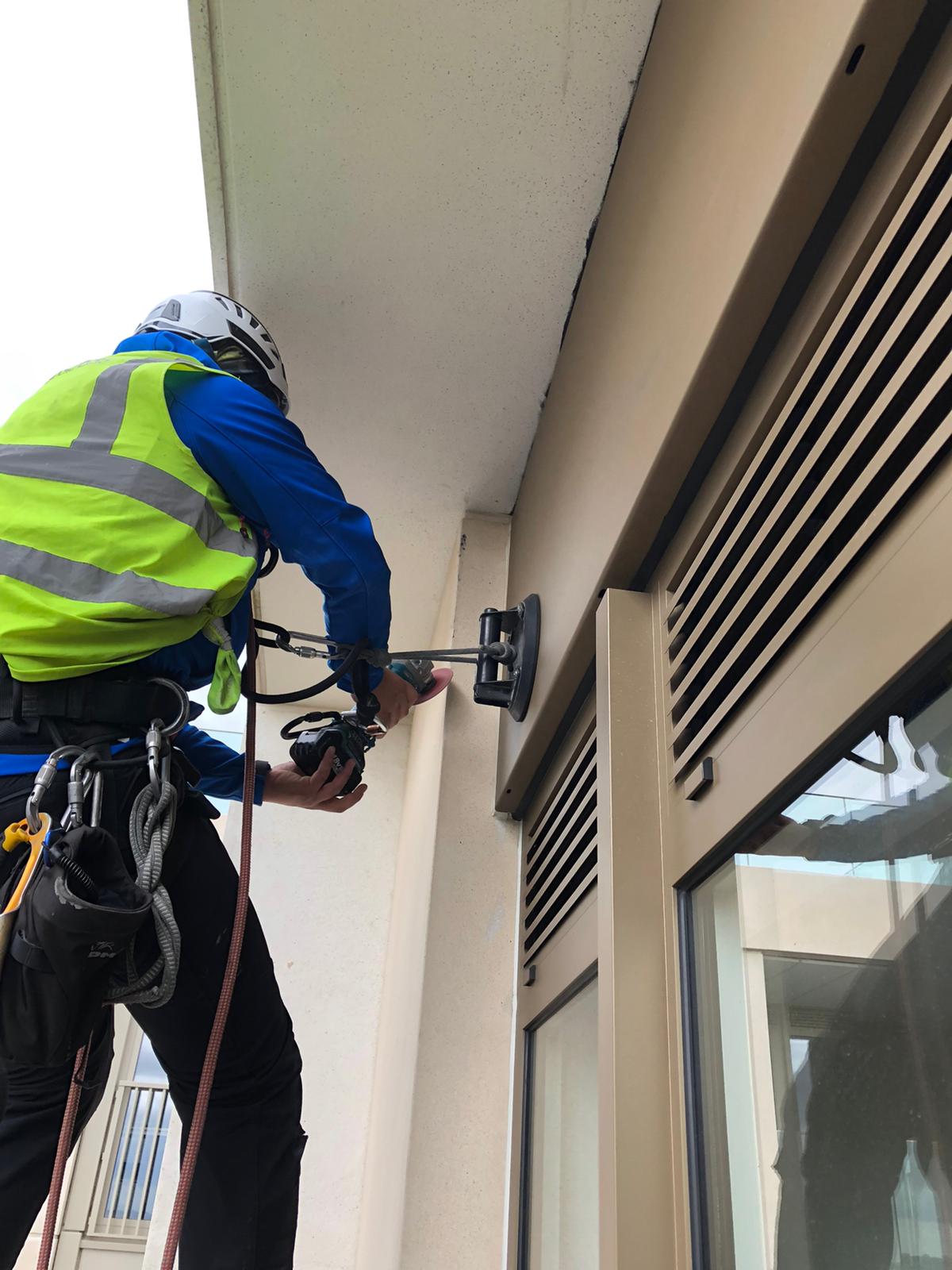Technical rope access works performed on a tower façade under controlled site conditions.