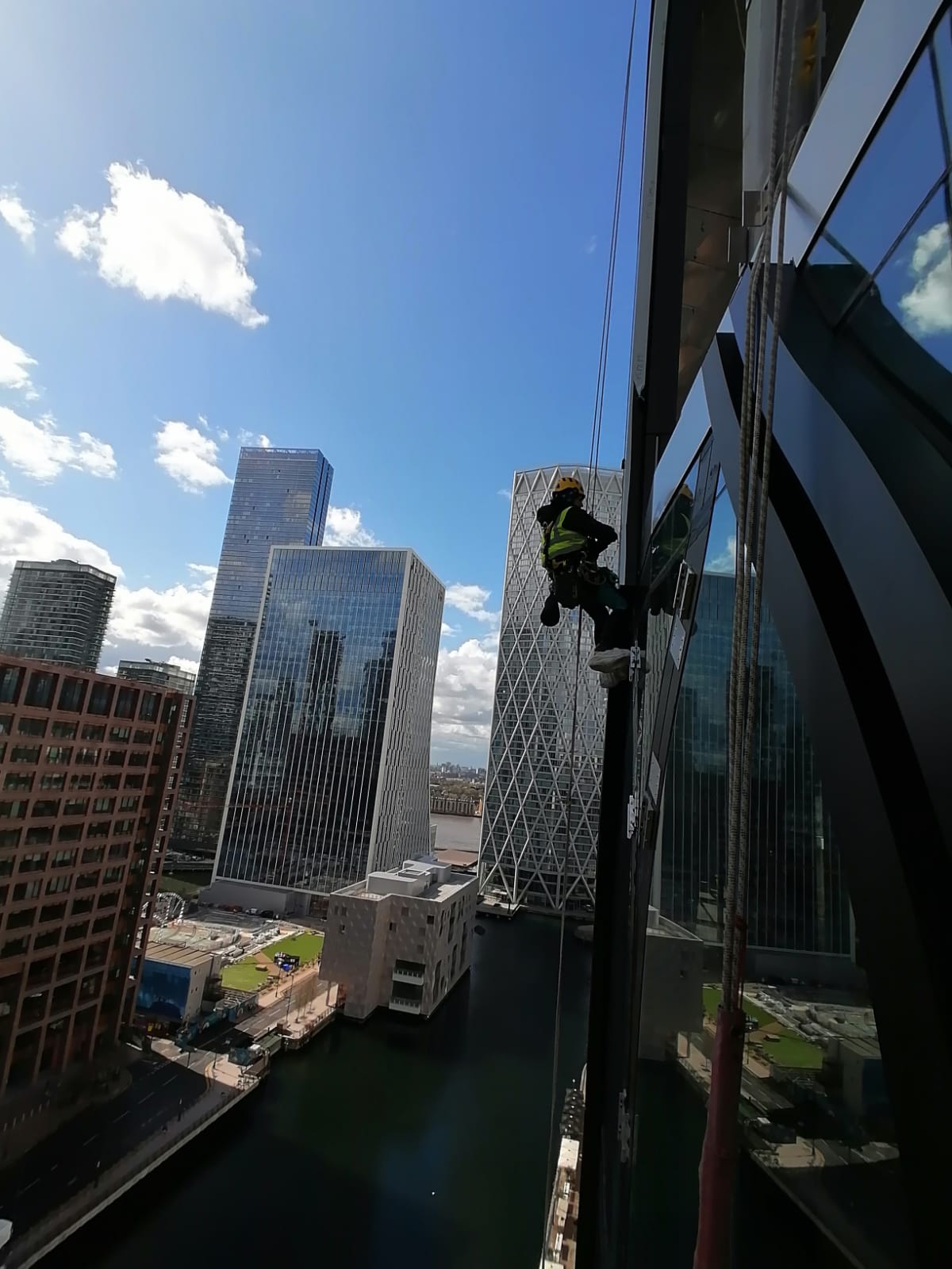 Rope access façade works completed along a glass elevation in a city centre environment.