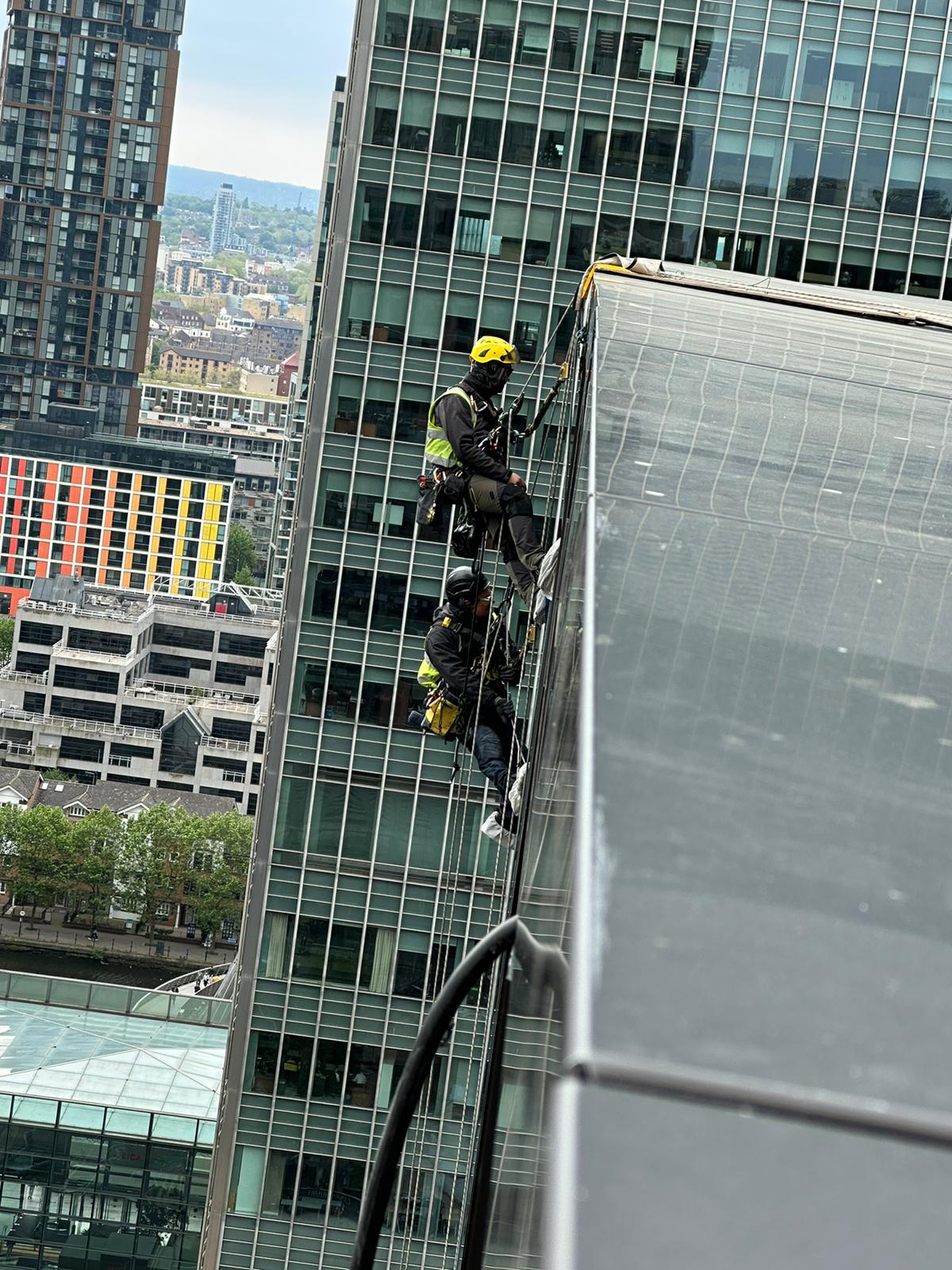 Rope access technicians conducting external façade works while maintaining safety and operational continuity.